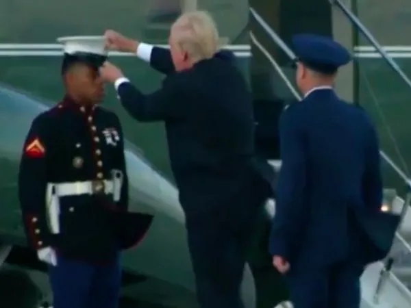 Трамп пытается вернуть солдату сорванную ветром фуражку